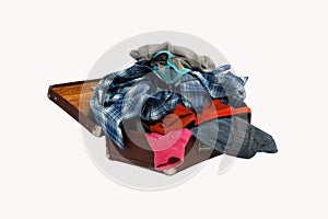 Stack of clothes in opened suitcase isolated on white background