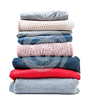 Stack of clothes sweaters and jeans on a white background. Isolated