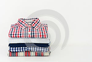 Stack of plaid shirts on white background