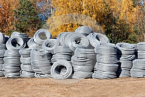 Stack of coiled plastic pvc Polyethylene Corrugated drainage pipes for sewer system outdoor warehouse