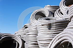 Stack of coiled plastic pvc Polyethylene Corrugated drainage pipes for sewer system outdoor warehouse