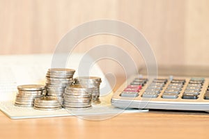 Stack of coins on account book with calculator - interest rate c