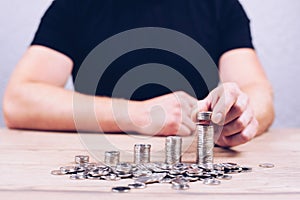 Stack of coins in ascending order. Businessman puts coins with his hand. Capital growth of interest deposit economy.