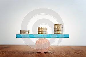 Stack of coins balance on seesaw