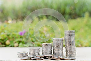 Stack coins on blurred green natural background. Property investment and house mortgage financial concept