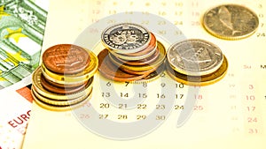 Stack of coins on calendar, closeup shot, for finance background