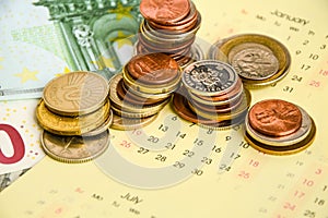 Stack of coins on calendar, closeup shot, for finance background