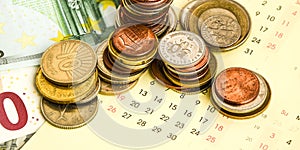 Stack of coins on calendar, closeup shot, for finance background
