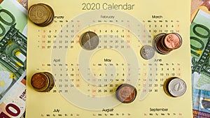 Stack of coins on calendar, closeup shot, for finance background