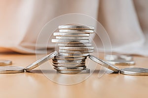 Stack of Coins Forming a Bridge on Wooden Surface photo