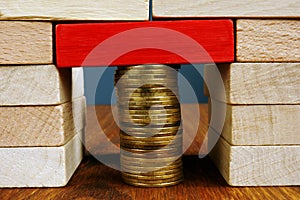 Stack of coins holds blocks. Financial balance and stability