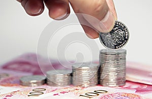 Stack of coins and human hand