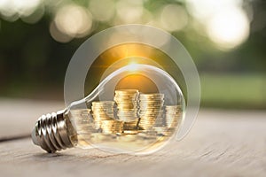 Stack of coins inside a light bulb for save money concept, Creative ideas of business planning, success in the future