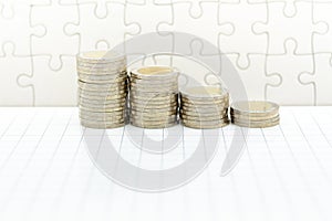 Stack of coins on jigsaw board. Image use for investment, business background concept