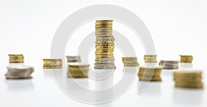 Stack of coins, a large bar with coins and a few small ones, isolated on white background. Growing and saving money concept.