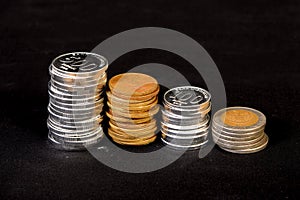 Stack of coins neatly arranged on black background