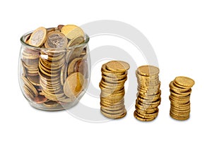 Stack of coins next to glass cup full of euro coins