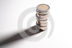 Stack of coins on white surface.