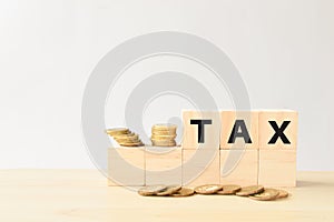 Stack of coins and wooden blocks with the word TAX