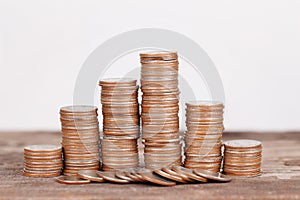 Stack of coins on wooden desk for saving money