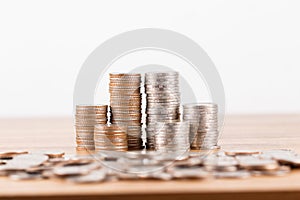 Stack of coins on wooden desk for saving money concept