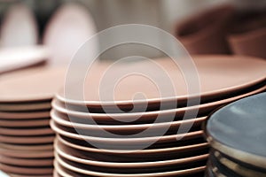 Stack of color ceramic plates in a store. Varieties of tableware. Set of kitchen plates on a store shelf