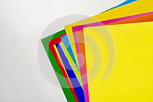 a stack of of color paper sheets on the table flat lay, view from above