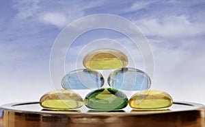 Stack of colored glass stones with a blue sky background and copy space.