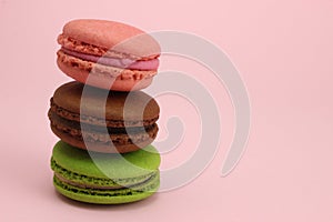 Stack of Colored macaroons or macarons on a pink background
