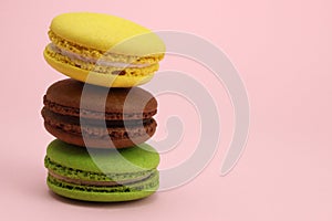Stack of Colored macaroons or macarons on a pink background