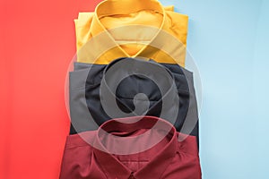 Stack of colored men shirt on red and blue background