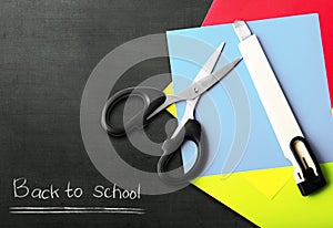 Stack of colored paper with scissors and cutter