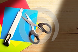 Stack of colored paper with scissors and cutter