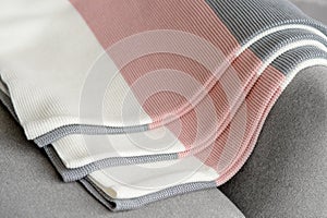 The stack of colored striped coverlets is on a gray background