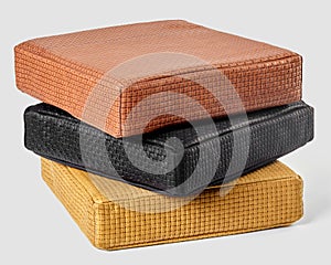 Stack of colorful artisanal leather cushions with woven texture