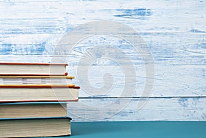 Stack of colorful books on the artistic wooden background. Free copy space. Back to school. Education concept.