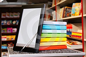 Stack of colorful books with e-book reader