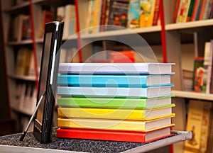 Stack of colorful books with e-book reader