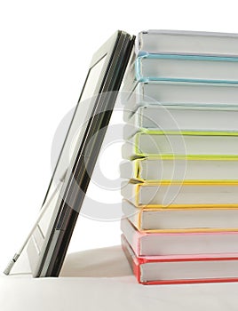 Stack of colorful books and electronic book reader