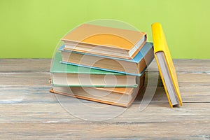 Stack of colorful books on wooden desk. Copy space for text.. Back to school. Education background.
