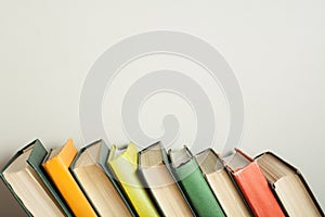 Stack of colorful books on wooden desk. Copy space for text. Back to school. Education background