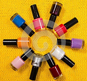 Stack of colorful bottles of nail polish arranged in a circle.