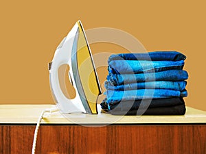 Stack of colorful clean towels  on white background. Ironing clothes on ironing board. Stack of clean towels on table. Colored tow