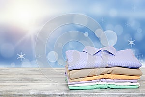 Stack colorful clothes. Pile of folded cotton shirts on a bright table with space for your display product montage over festive