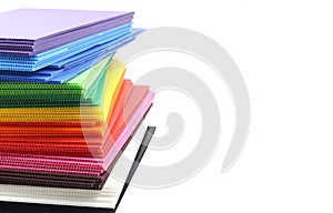 Stack of colorful corrugated plastic sheets isolated on white background