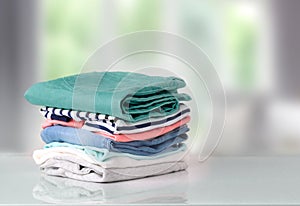 Stack colorful cotton clothes on table empty space background.