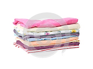 Stack of colorful cute girl clothes. A pile or heap of freshly washed and ironed colorful cute girl clothes isolated on white