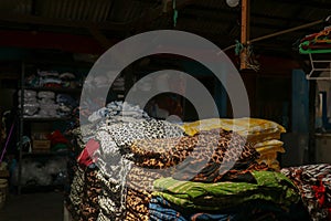 stack of colorful fabrics in a dark warehouse tailor's workshop