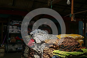 stack of colorful fabrics in a dark warehouse tailor's workshop