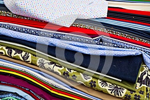 Stack of colorful fabrics showing various patterns and textures